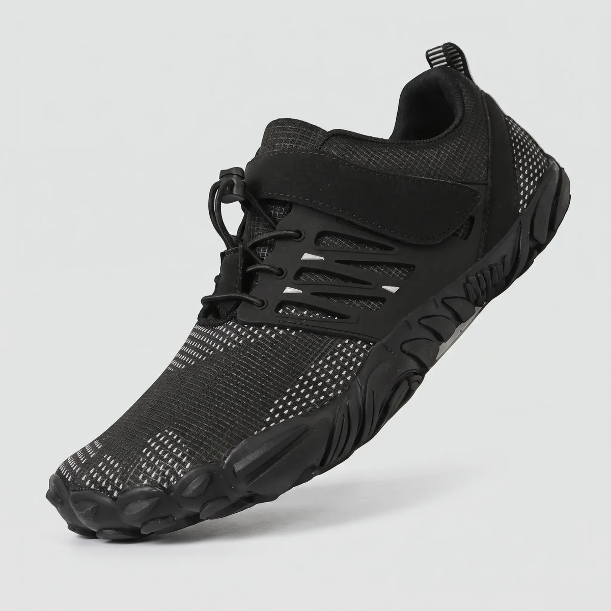 Black barefoot shoe at a three-quarter angle showing the wide toe box, strap and quick-pull lace