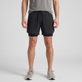 Man wearing the Black 2 in 1 running shorts, front view with running shoes