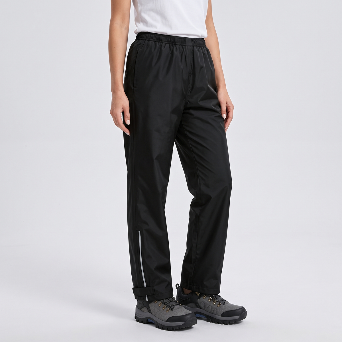 Women's rain trousers three-quarter view with the reflective strip and ankle tab on the outer leg