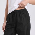 Elasticated drawcord waist and zip side pocket of the women's rain trousers