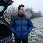 Man in the Navy colour block puffer jacket standing at a car boot on a frosted verge at first light