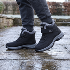 Black fur lined winter boots worn on a frosty stone pavement in Britain