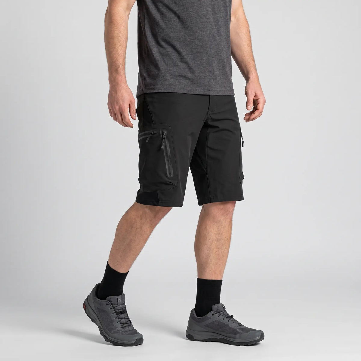 Black MTB shorts worn, three-quarter side view of the zipped cargo pocket