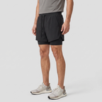 Three-quarter side view of the Black 2 in 1 running shorts showing the split vented hem