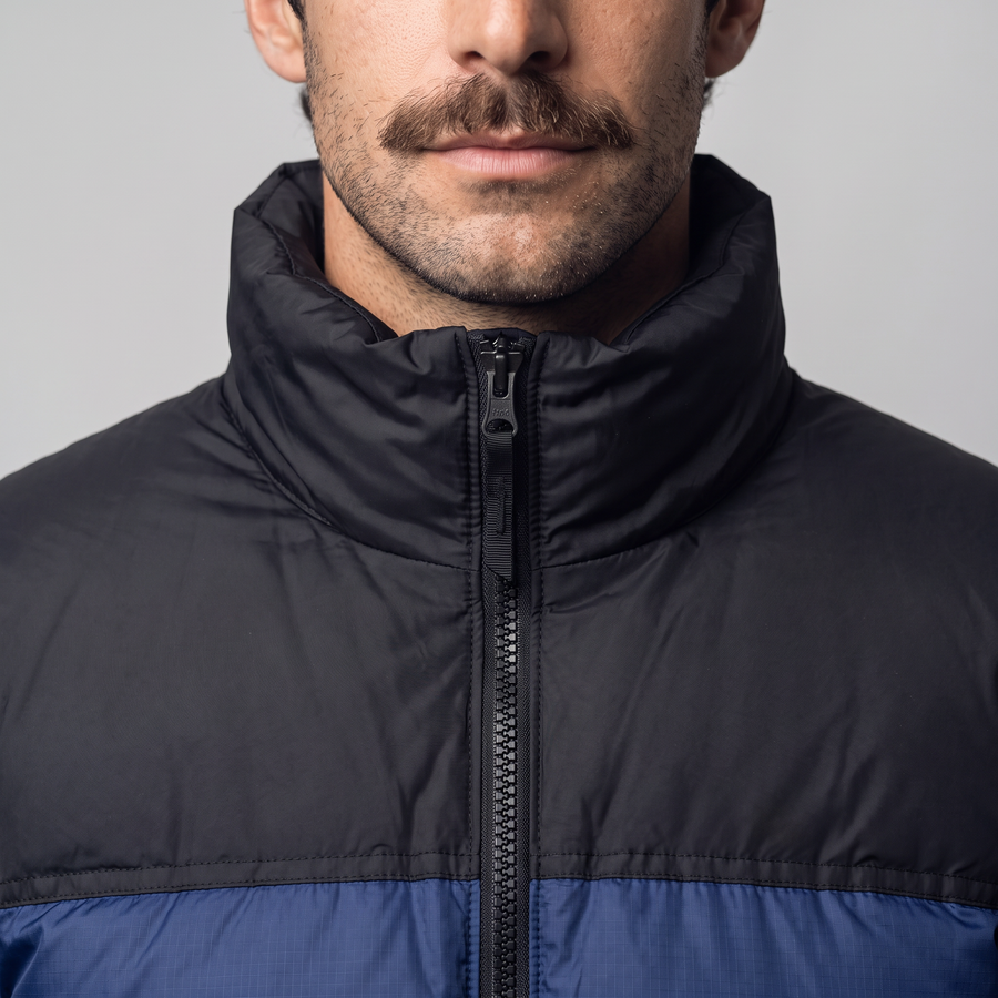 Tall padded stand collar of the Terrabound colour block puffer jacket zipped up under the chin