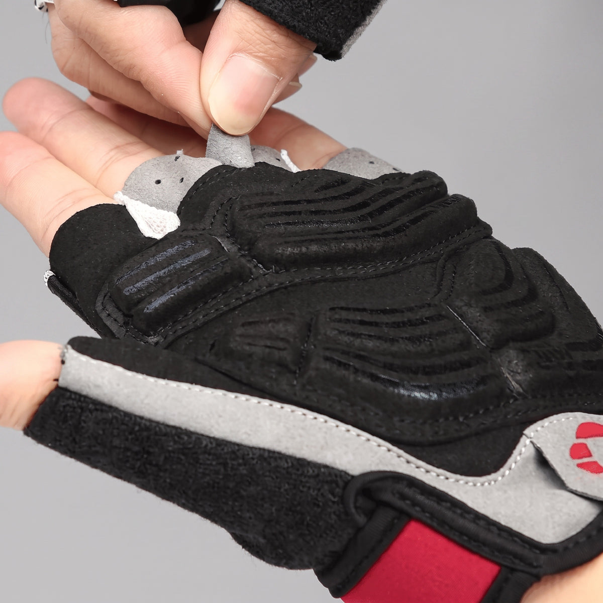 Pull tabs between the fingers used to take the cycling gloves off in one motion