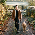 Man walking his dog on a country lane in the Tobacco Brown sherpa jacket