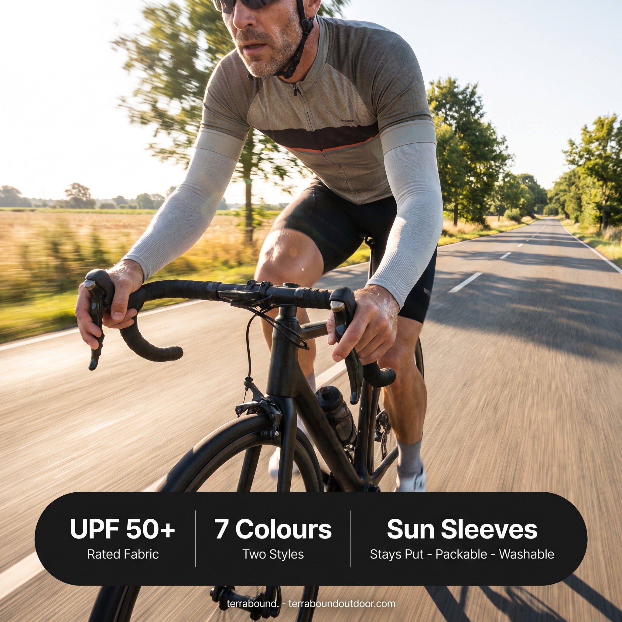 Cyclist wearing UPF 50+ arm sleeves on an open road