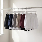 All six colourways of the 2 in 1 running shorts on a rail: Black, Navy, Light Grey, Khaki, Burgundy and White