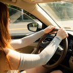 Driver wearing UPF 50+ arm sleeves against sun through the car window