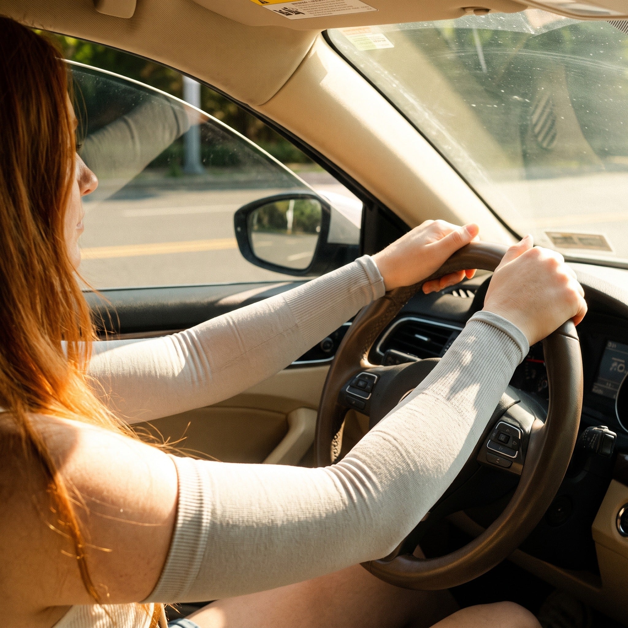 Driver wearing UPF 50+ arm sleeves against sun through the car window