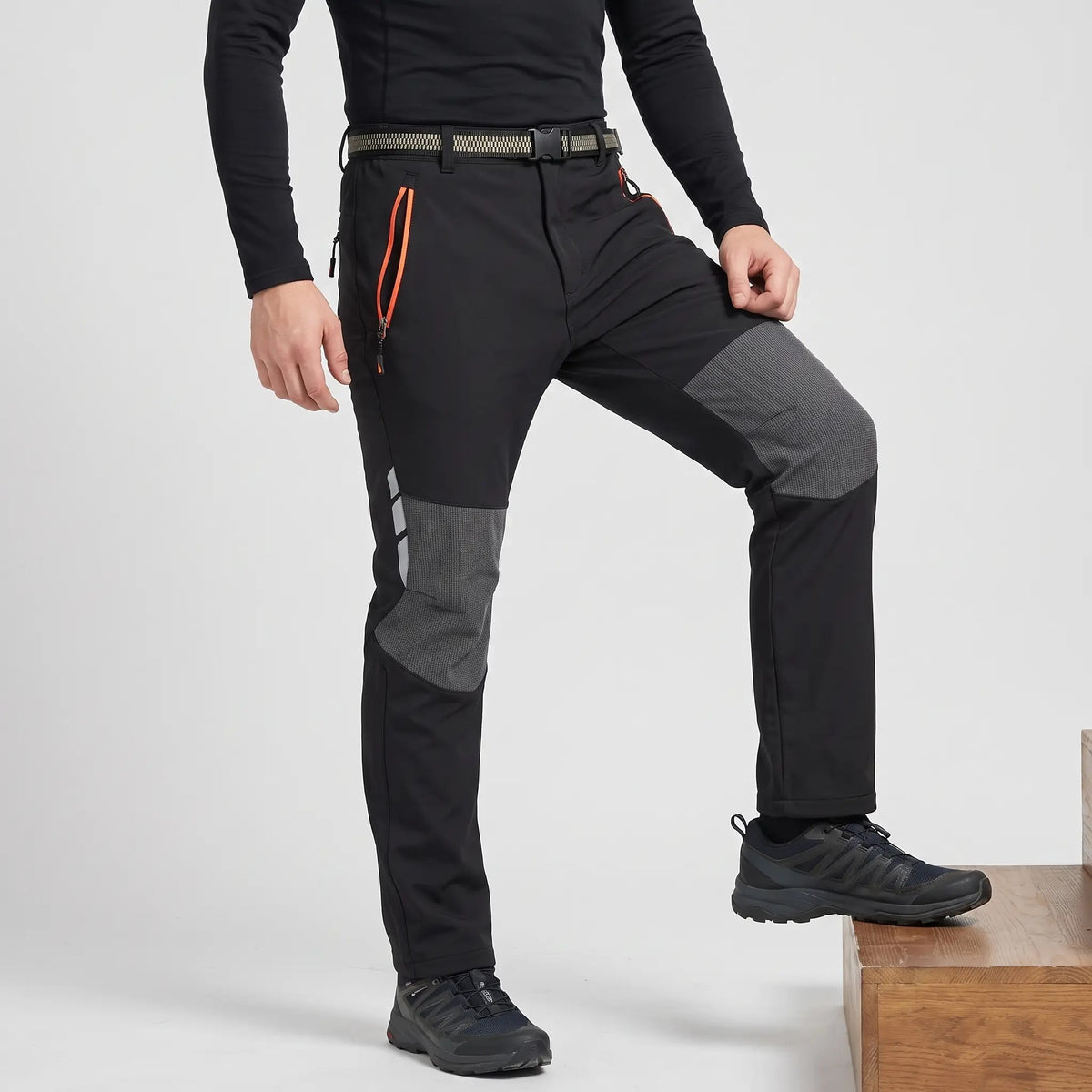 Men's fleece lined walking trousers in Black, side view with knee bent