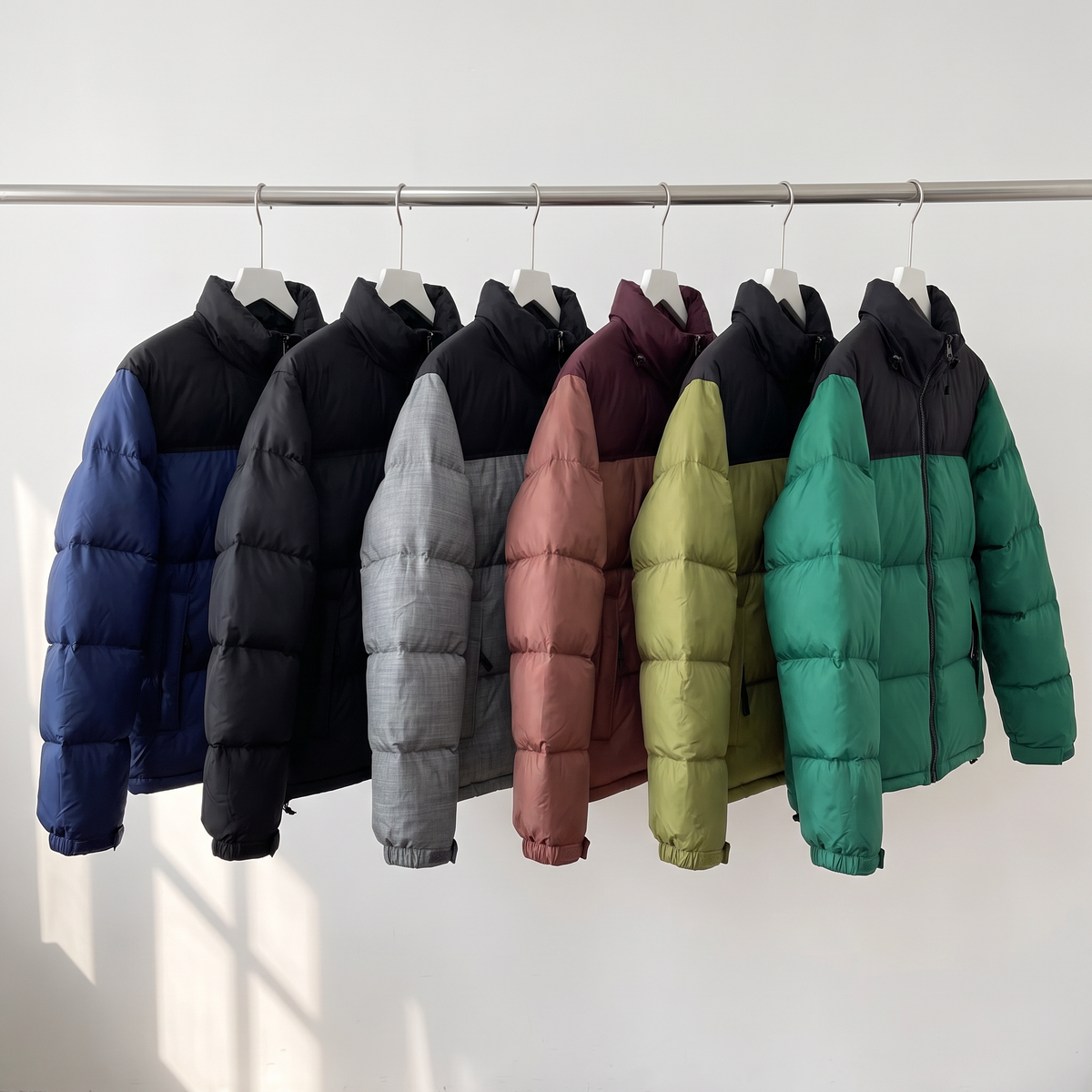 All six colourways of the men's colour block puffer jacket hanging on a rail
