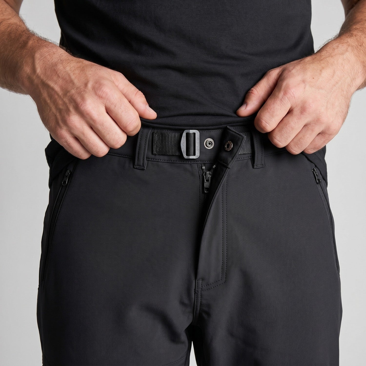 Close-up of the adjustable webbing waist buckle and zip hip pocket