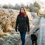 Woman walking a dog on a frosty British lane wearing the Crimson Fleece Snood