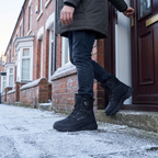 Man stepping out of a British front door on a frosty morning wearing the snow boots