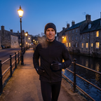 Man running on a riverside path in a British town at dusk wearing the gloves