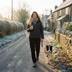Woman walking her dog on a frosty village lane in black fleece lined joggers
