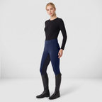 Woman wearing navy two-tone pull-on riding breeches with a black top and tall riding boots