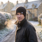 Man wearing the black beanie on a frosty village lane in Britain