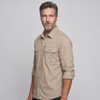 Man wearing the men's fishing shirt in Khaki with the sleeves rolled up and buttoned on their tabs