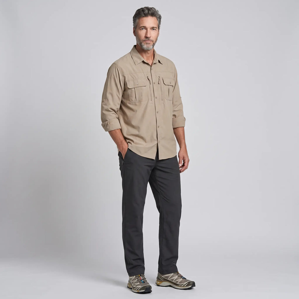 Man wearing the men's fishing shirt in Khaki, untucked with outdoor trousers and trail shoes
