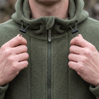 Hands drawing the hood cord closed on the fleece jacket