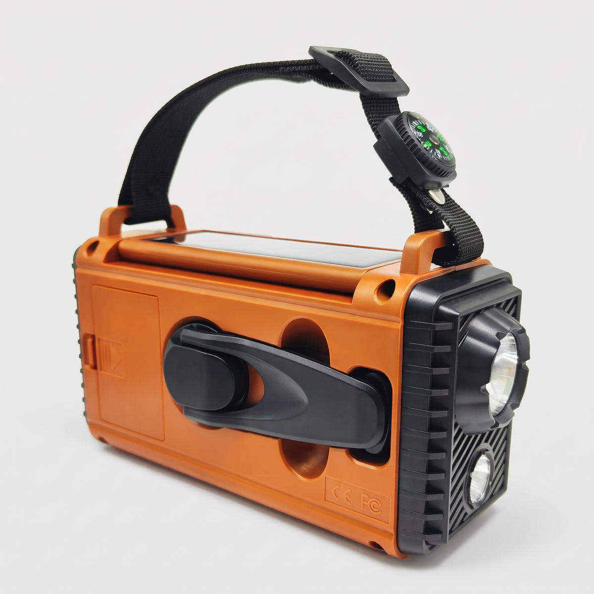 Back of the portable radio with fold-out hand crank, AAA battery cover and solar panel lid