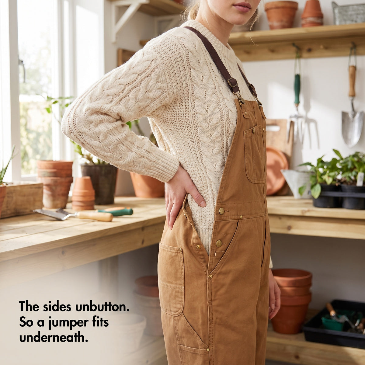 Buttoned side opening of the dungarees worn open over a cable-knit jumper