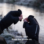 Hands tying a hook onto fishing line on a frosty riverbank with the thumb and index caps folded back