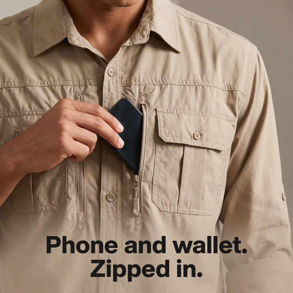 Phone sliding into the zip chest pocket of the men's fishing shirt in Khaki