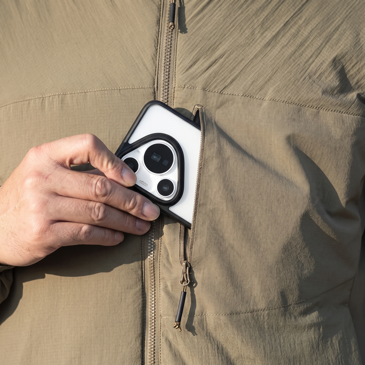 Phone going into the zipped chest pocket of the jacket