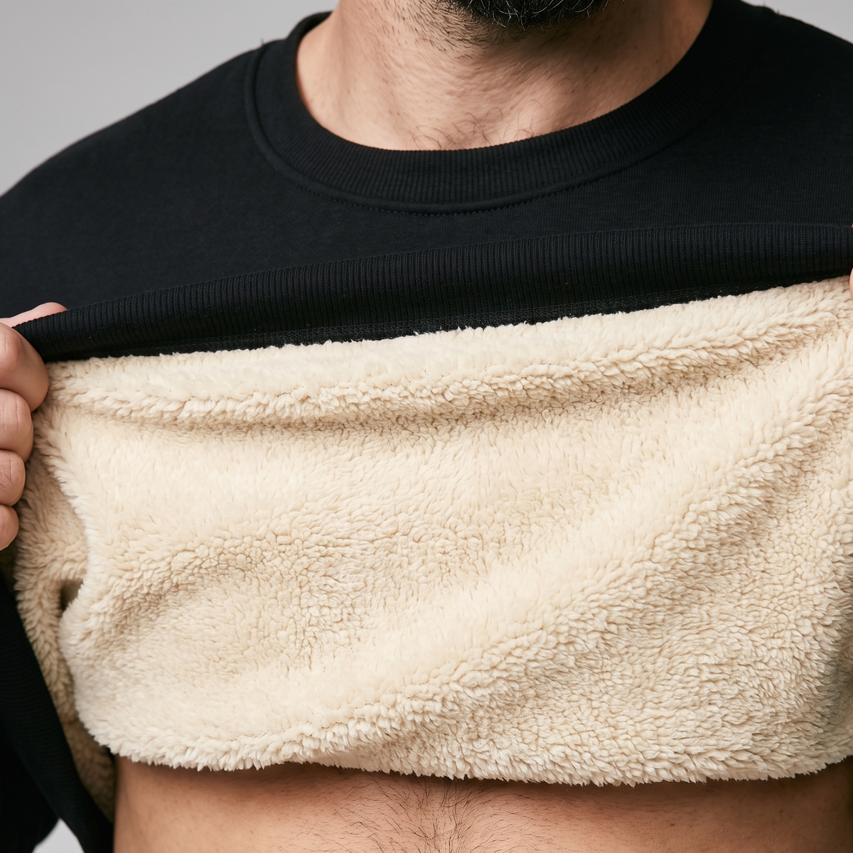 Close-up of thick cream sherpa fleece lining inside black jumper collar