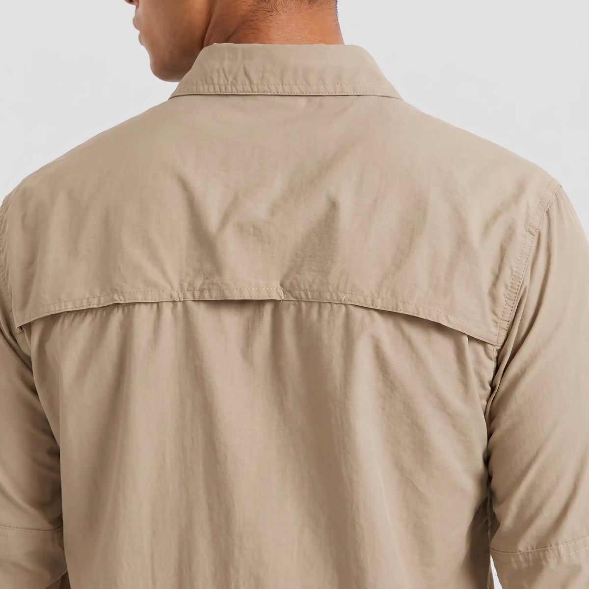Close-up of the vented yoke across the back of the men's fishing shirt in Khaki