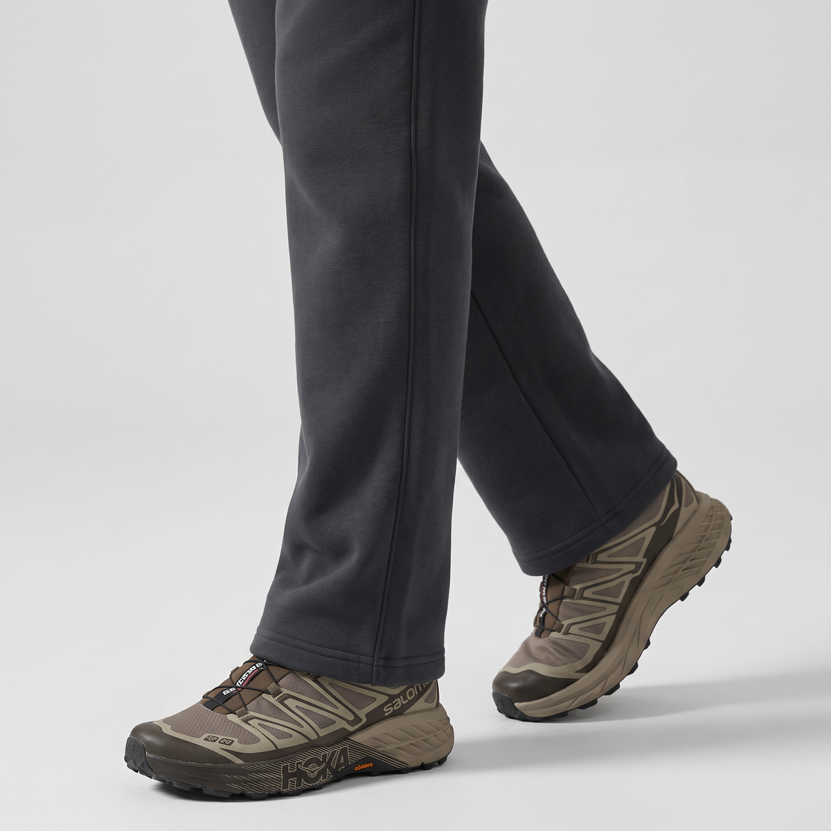 Close-up of the open straight hem falling over a trail shoe with no ankle cuff