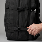 Hand tightening a side compression strap on the 45L rucksack
