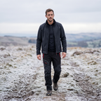 Man walking a frosted upland path in the insulated winter walking trousers