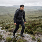 Walker crossing open moorland in black walking trousers