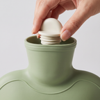 Hand screwing the stopper into the hot water bottle