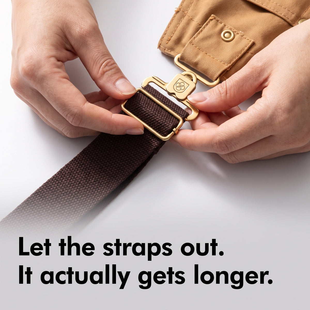 Hands adjusting the buckle on the crossback strap of the canvas bib dungarees
