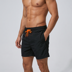 Black men's swim shorts, three-quarter side view with hand in side pocket
