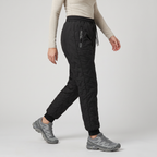 Women's fleece lined quilted trousers worn, Black, cuffed ankle, side view walking
