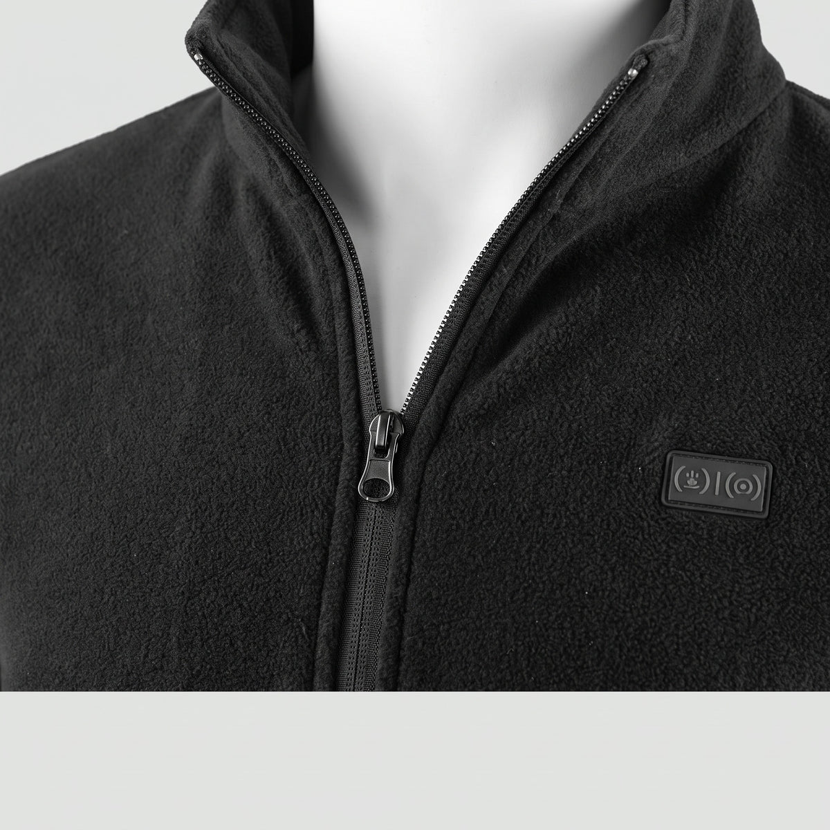 Close-up of the front zip and chest badge of the heated jacket