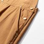 Buttoned side opening along the seam of the camel canvas dungarees