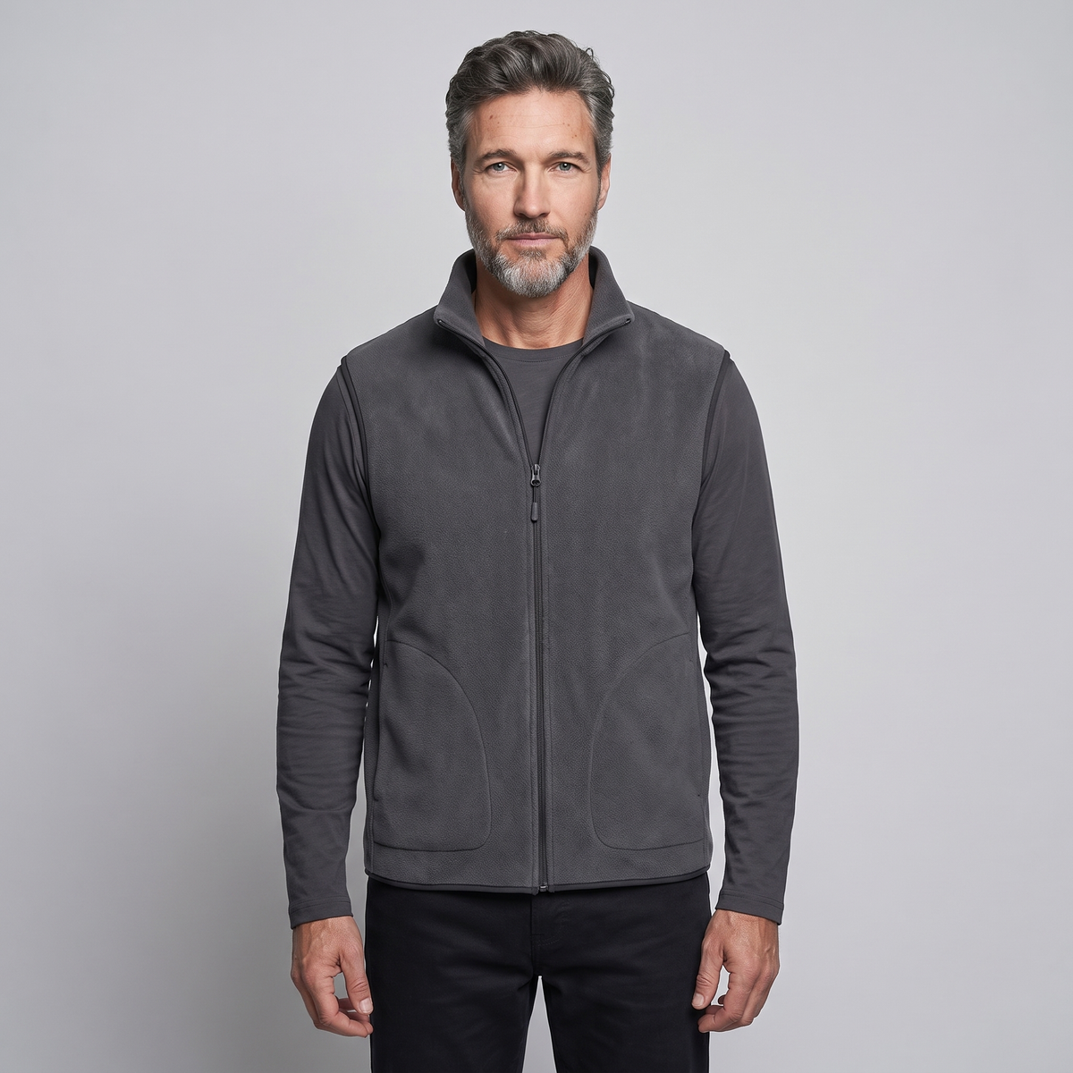Man wearing the charcoal men's fleece vest over a long-sleeved top, front