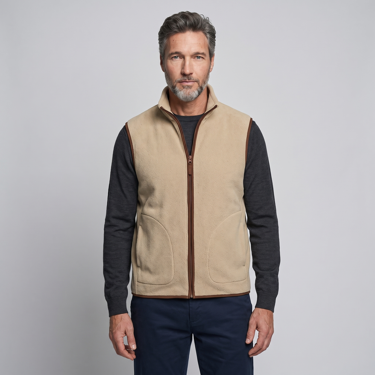 Man wearing the khaki men's fleece vest over a long-sleeved top, front