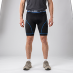 Man wearing the blue padded cycling liner shorts, black mesh with blue seams, front view