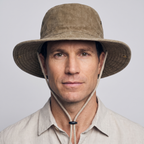 Man wearing the Khaki wide brim sun hat with the brim down and the chin cord under his jaw