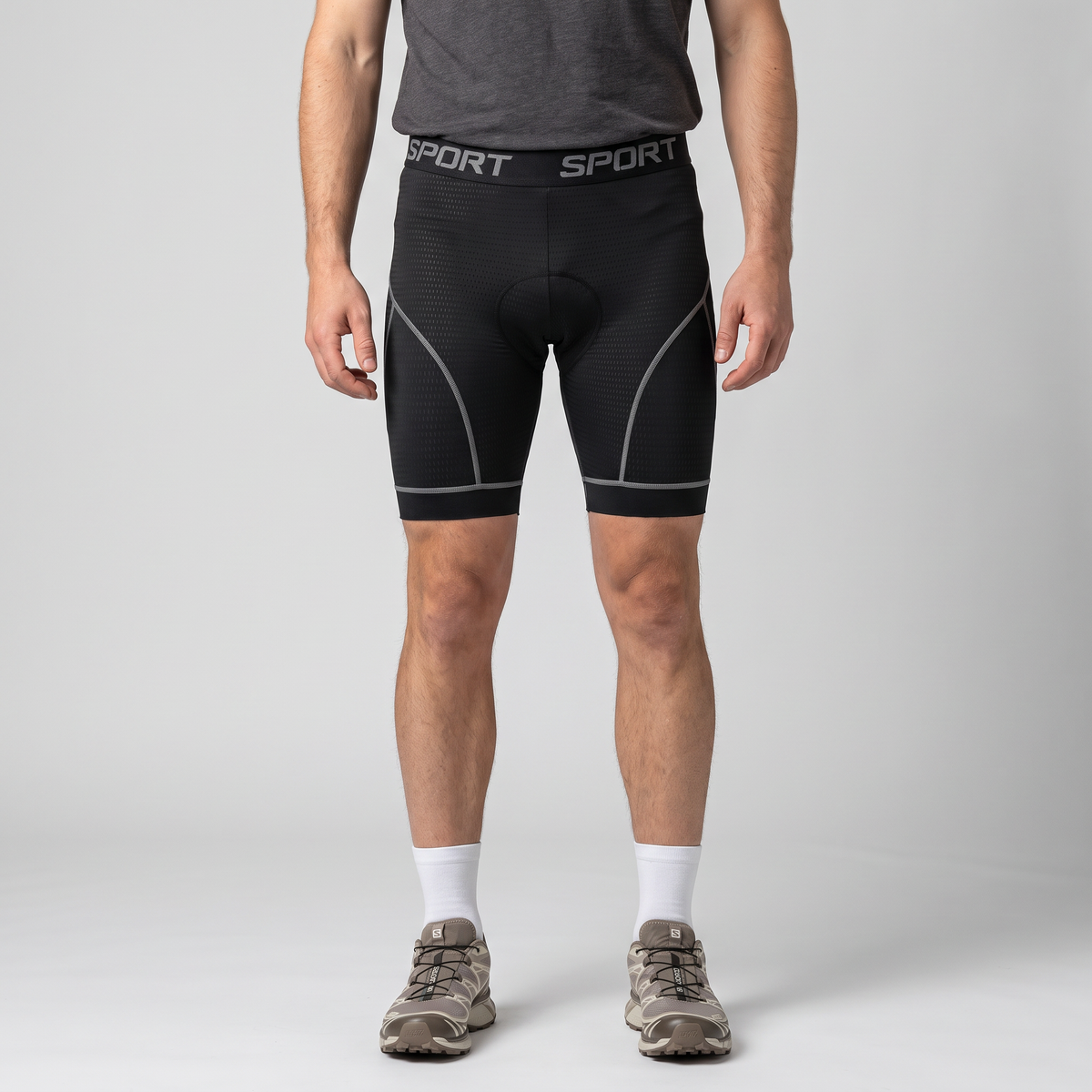 Man wearing the grey men's padded cycling liner shorts, front view from chest to shoes