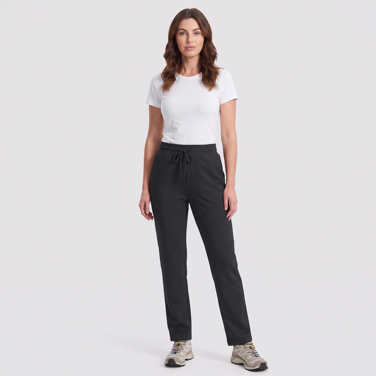 Woman wearing the black fleece lined joggers with a white t-shirt and trail shoes, full length